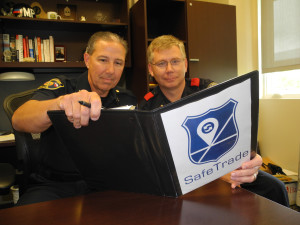 Chief Bryan Sylvester and Lt. Marty Cassidy review guidelines in the Safe Trade manual.