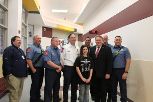 Madison Conner, shown center, was recognized at Draper Intermediate School last week for her life-saving efforts. Also pictured are Aaron Oleson, Captain Brandon Gibson, Jeff Pynes, Chief Brent Parker, Richard Hollien, Mayor Eric Hogue, Captain Casey Nash and Andrew Johnson.