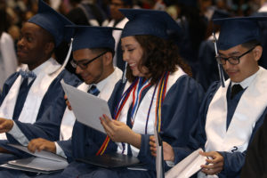 Sachse High School 2016 graduates are all smiles as they open their envelopes to look at their diplomas.