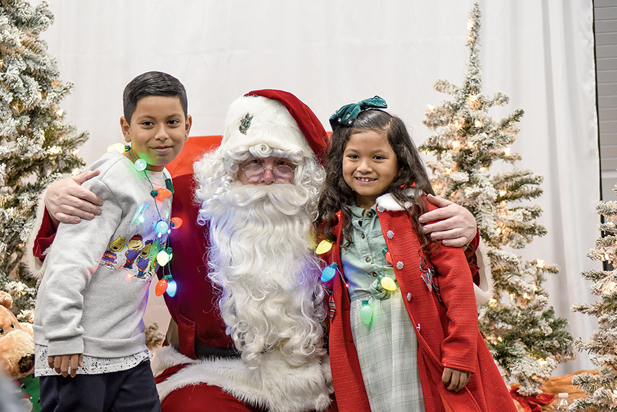 Julian, 9, and sister Ariana, 7, pose with Santa.